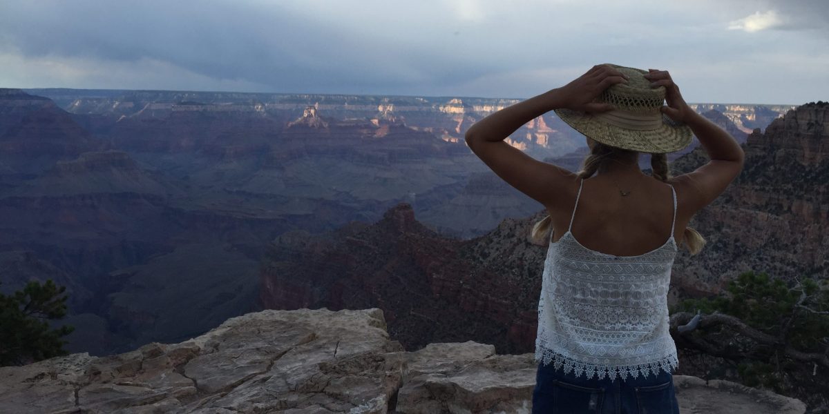 Anna holding her hands on her head with her back to the camera with the Grand Canyon in the background
