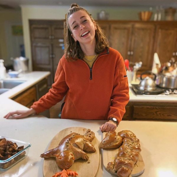 Hazel smiling behind two loaves of bread that are shaped like animals