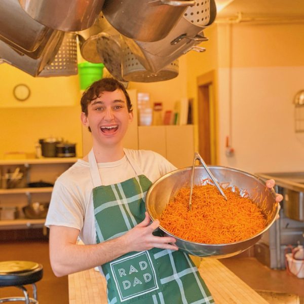 Nicolo smiling at the camera while holding a large bowl of food