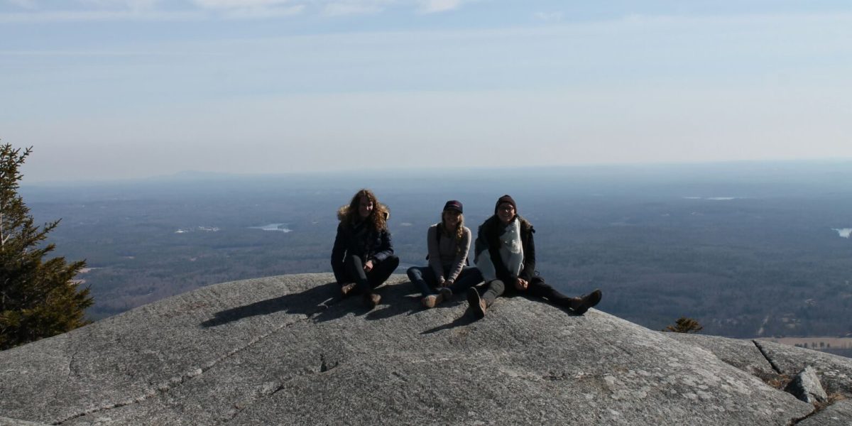 Anna and friends smiling at the camera on the top of Mount Manadnock