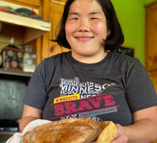 Photograph of Nae Nae by Nicolo. Nae Nae is smiling and holding a pie fresh out of the oven.