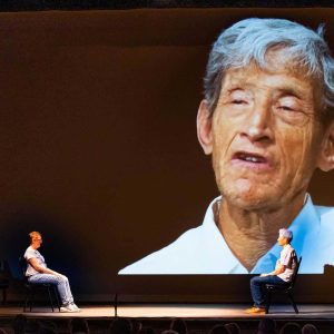 Elias is projected large onto a screen behind the stage during a Camphill Hudson performance